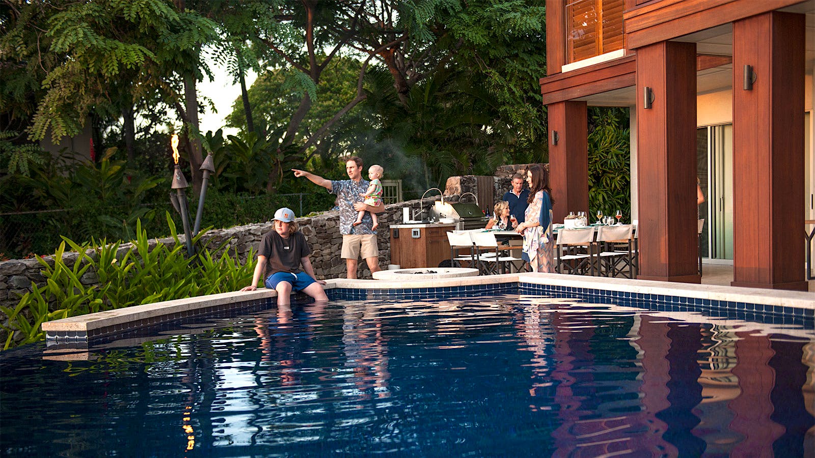 The Hall's extended family gathers around the outdoor kitchen and pool area. 